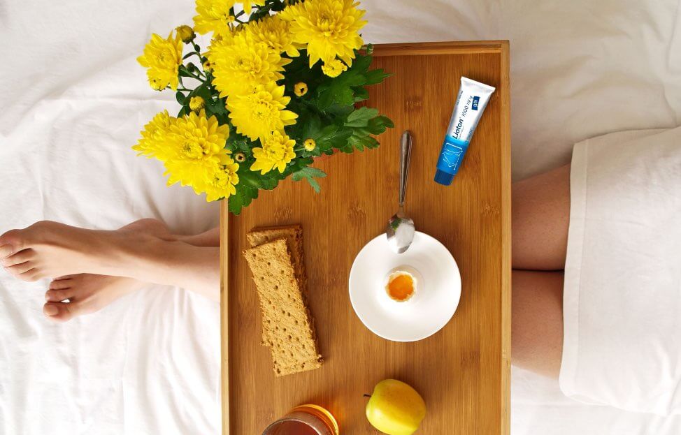 ლიოტონი® 1000 გელის ტუბი საწოლზე, რომელიც დაგეხმარებათ ვენური უკმარისობის სიმპტომების შემსუბუქებაში