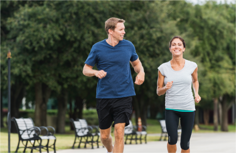 კარგი იუმორის მქონე წყვილი იცინის და დარბის პარკში ლიოტონი®1000 გელის გამოყენების შემდეგ